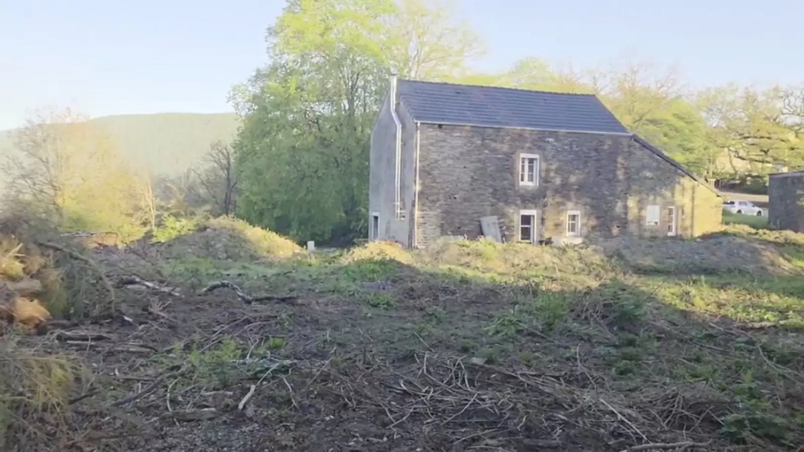 Débroussaillage et remise en forme d'un terrain autour d'un bâtiment